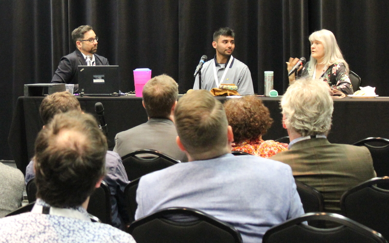 committee speaks in front of an audience with listeners 