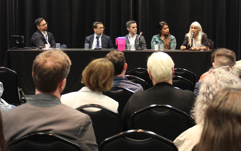 committee speaks in front of an audience with listeners 