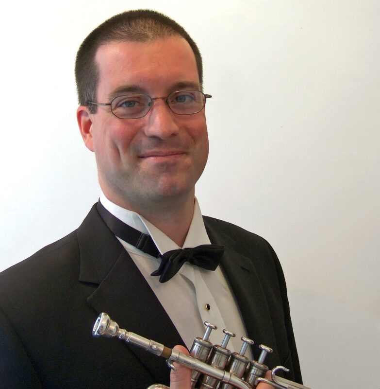 A headshot of Richard Sandals holding a trumpet