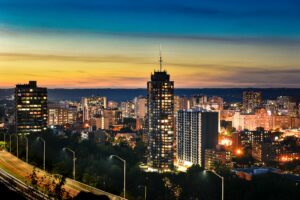 City skyline of Hamilton, Canada at sunset with orange and blue sky.